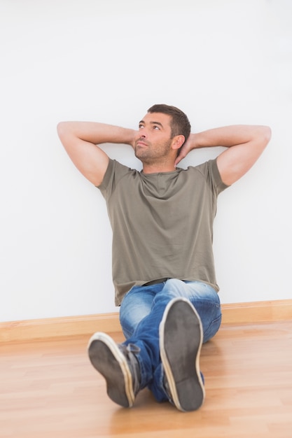 Foto casual hombre sentado en el piso en casa en la sala de estar