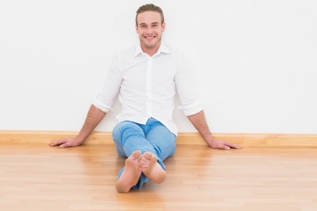 Foto casual hombre sentado en el piso en casa