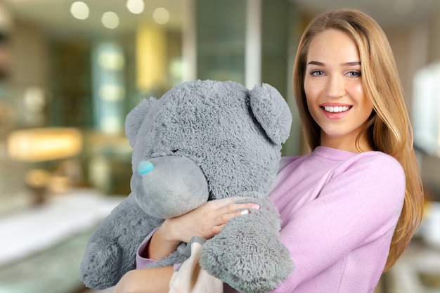 Casual joven sonriente con oso de peluche