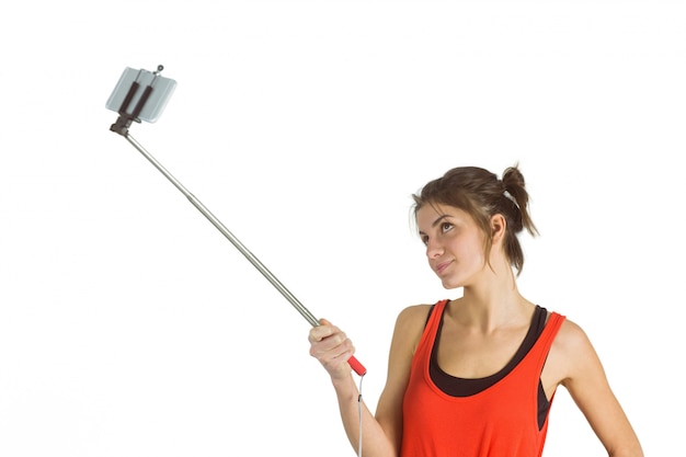 Casual morena usando selfie stick