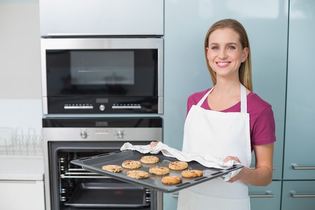 Casual mujer feliz con bandeja de horno con galletas