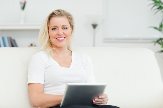 Casual mujer sentada en un sofá con un ebook