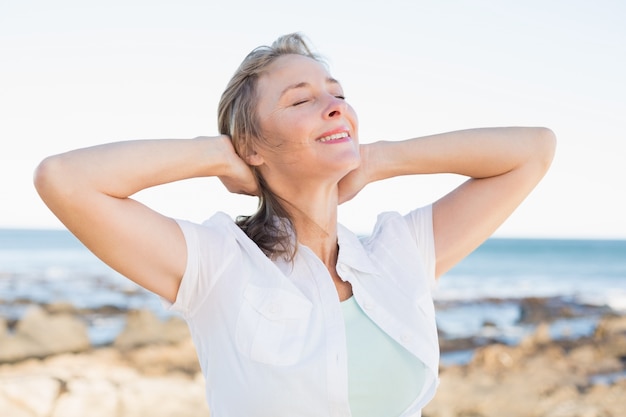 Casual mujer sonriendo junto al mar