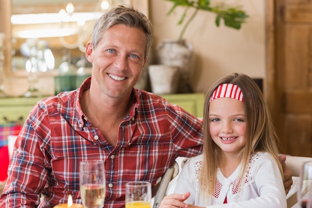 Casual padre e hija sonriendo a la cámara