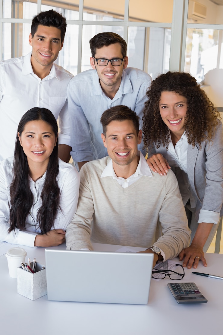 Foto casual sorridente equipe de negócios tendo uma reunião usando laptop