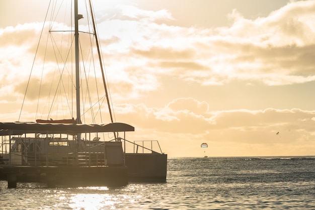 Catamarã ancorado na praia de waikiki ao pôr do sol em honolulu, havaí