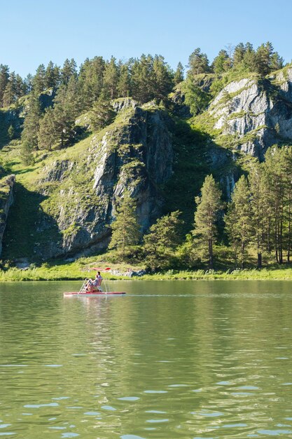 Catamarã com pessoas no fundo das montanhas com espaço de cópia