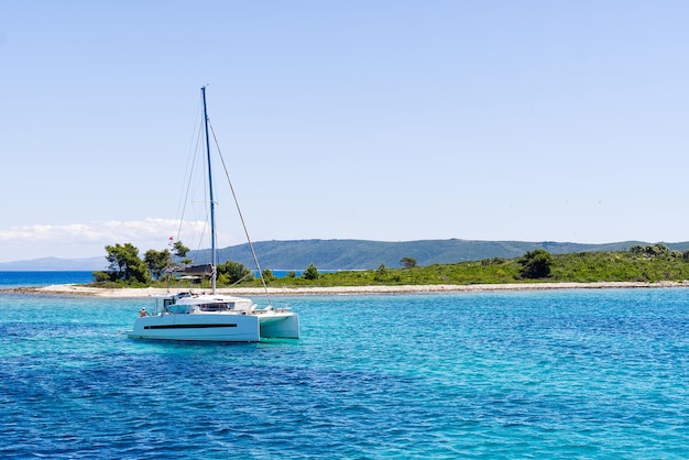 Catamarã navegando no paraíso oceânico no mar Céu azul e água do mar azul turquesa