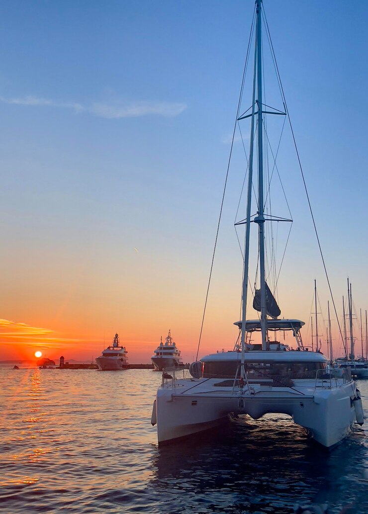 Foto un catamarán está anclado en el agua al atardecer