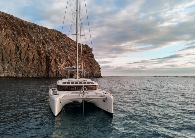Foto catamarán moderno y solitario amarrado en las aguas tranquilas del océano atlántico cerca de las islas canarias, españa