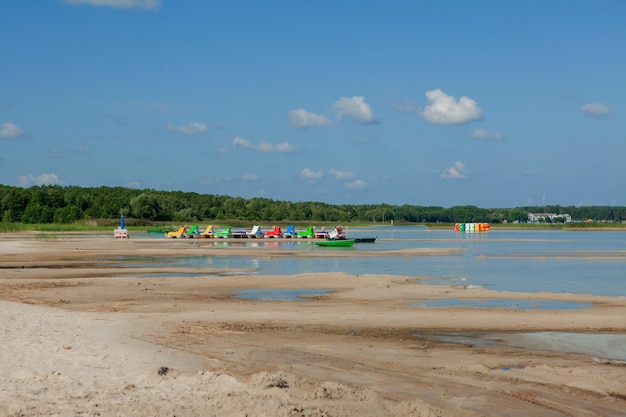 Catamaranes en la playa Botes de pedal de colores brillantes en la playa del mar Transporte acuático para divertirse Tobogán de agua
