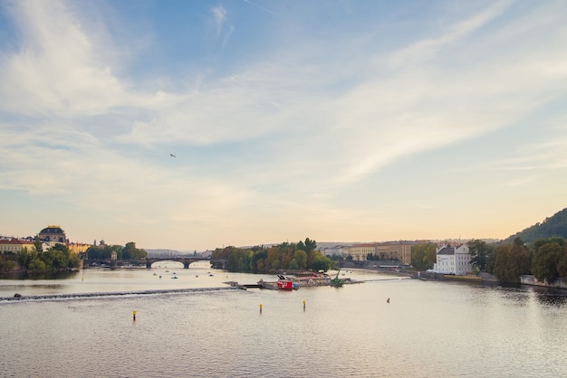 Catamarãs no Rio Vltava, perto da Ponte Carlos, na luz do sol. Cidade velha de Praga.