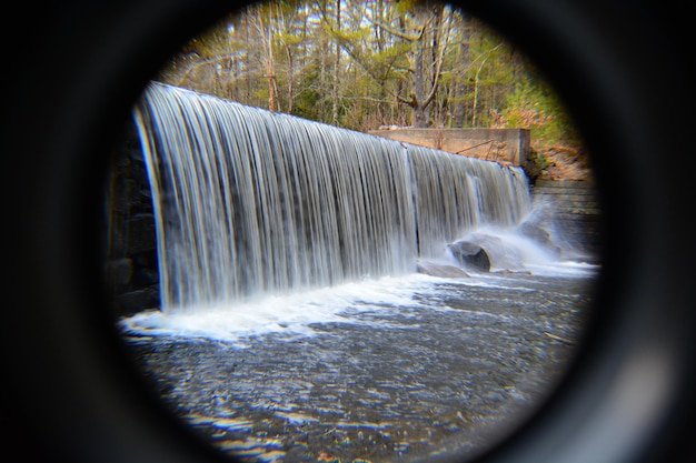 Foto catarata en el bosque vista a través de un agujero