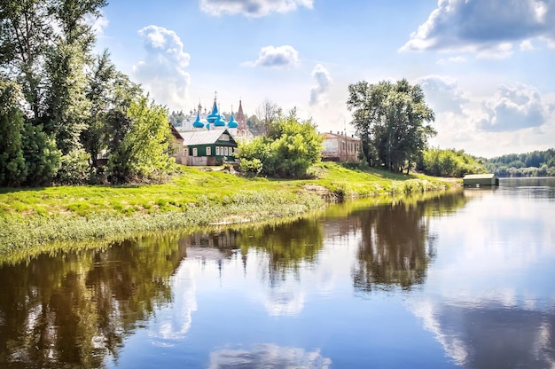 Catedral de la Anunciación con cúpulas azules y casas con reflejo en el río Klyazma Gorokhovets
