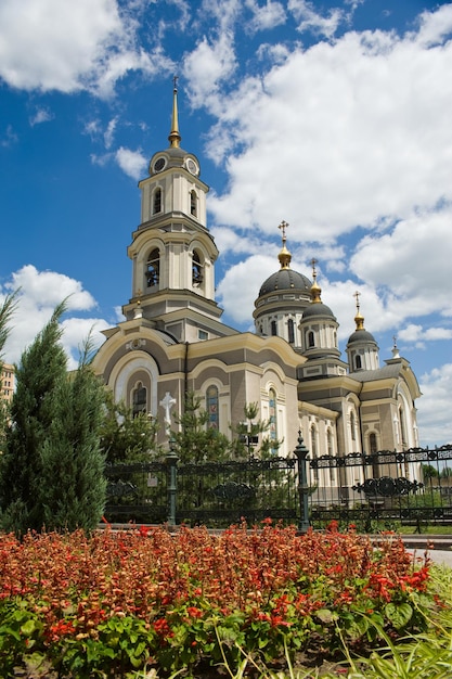 Catedral de Donetsk con flores sobre un fondo de cielo azul