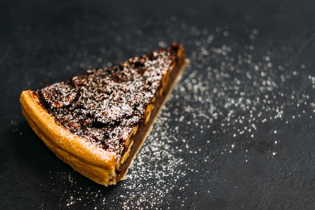 Catering profesional. Primer plano de una tarta de nueces con melaza espolvoreada con azúcar en polvo.