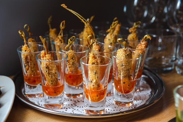 Catering-Service Gebratenes Fingerfutter in süßer Chili-Sauce Vorspeisen in Gläsern auf dem Tisch