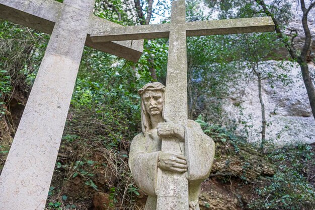 Católica, escultura de Jesús en la cruz hecha en piedra en el monasterio de Montserrat en Barcelona, España