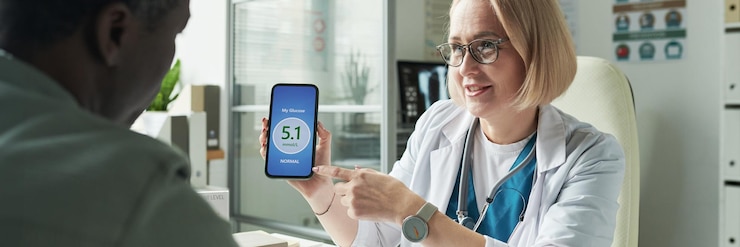 Foto caucasian middle aged female doctor displaying glucose reading to black man