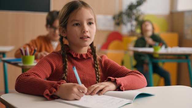 Caucasiana inteligente feliz menina escola teste estudo tarefa exame escrever anotações aula aprender