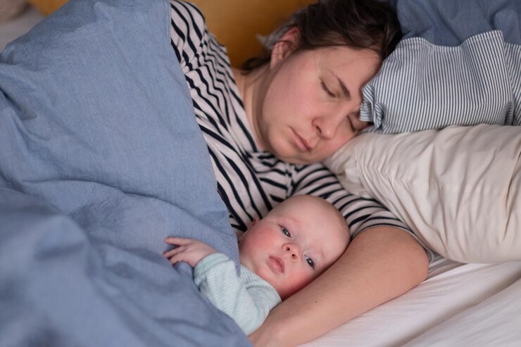 Caucasiana jovem mãe e seu bebezinho dormindo na cama