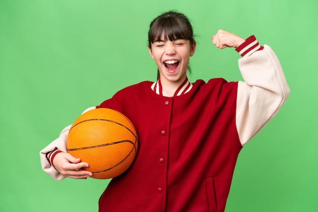 Caucasiana menina jogando basquete sobre fundo isolado, fazendo um gesto forte