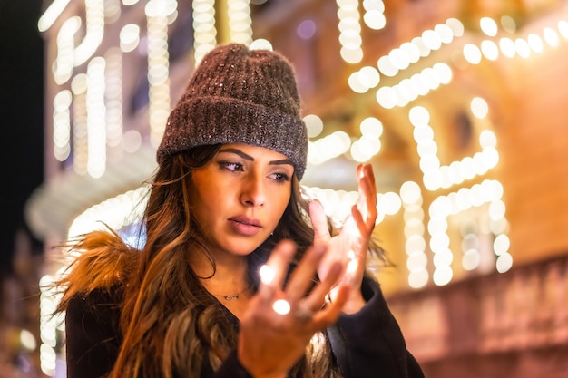 Caucásico en la ciudad por la noche junto a las luces de Navidad