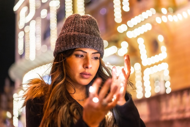 Caucásico en la ciudad por la noche junto a las luces de Navidad