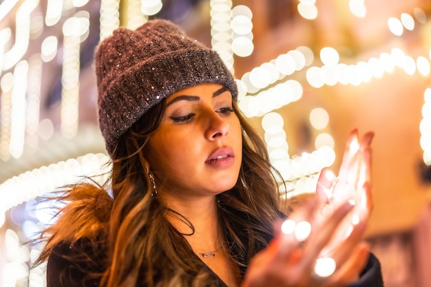 Caucásico en la ciudad por la noche junto a las luces de Navidad