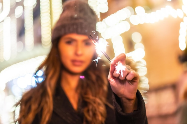 Caucásico en la ciudad por la noche junto a las luces de Navidad