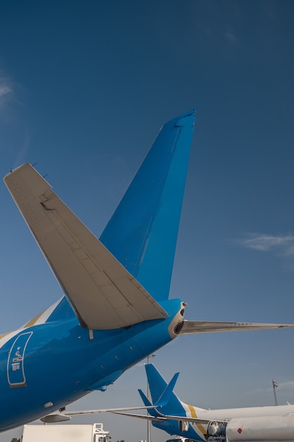 Cauda de aeronaves das companhias aéreas internacionais no aeroporto com céu azul ao fundo. Avião, conceito de transporte