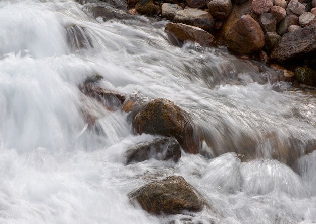 El caudal de un río de montaña con piedras redondeadas.