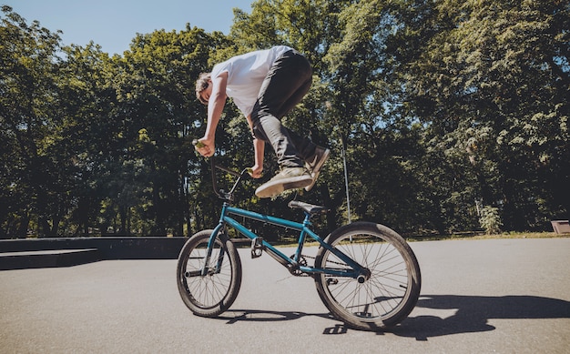 Cavaleiro de BMX que executa truques no skatepark.