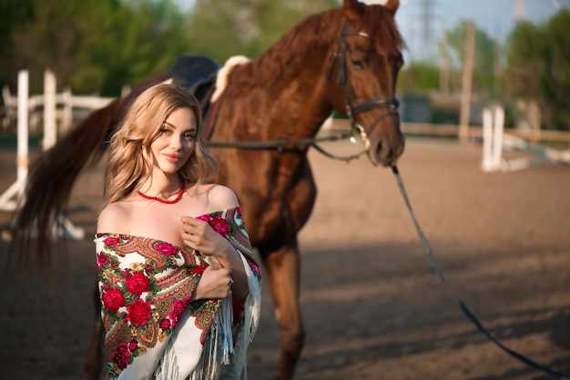 Cavalo e mulher em um lenço no rancho.