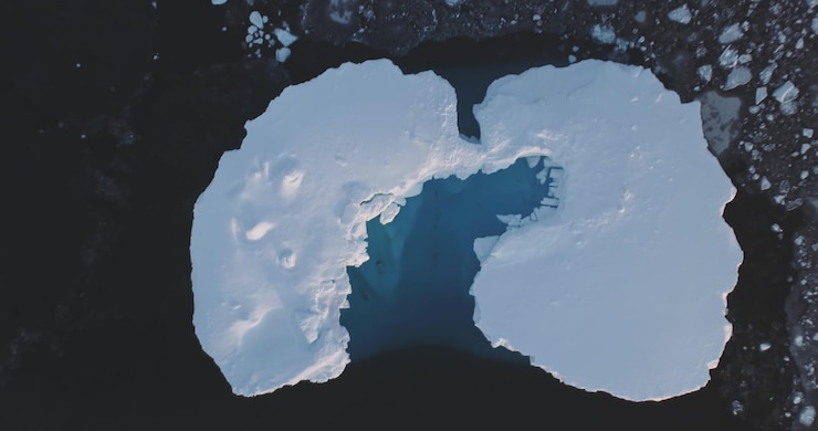 Foto caverna de derretimento em gelo flutuante iceberg coberto de neve vista aérea de cima para baixo flutuar geleira no polar congelado gelado