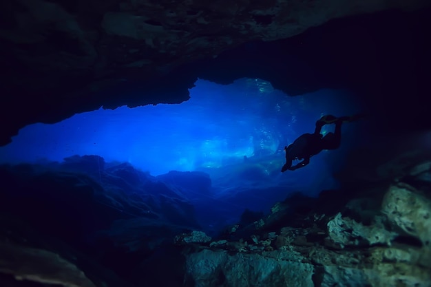 caverna mundial subaquática do cenote de Yucatan, paisagem escura de estalactites no subsolo, mergulhador