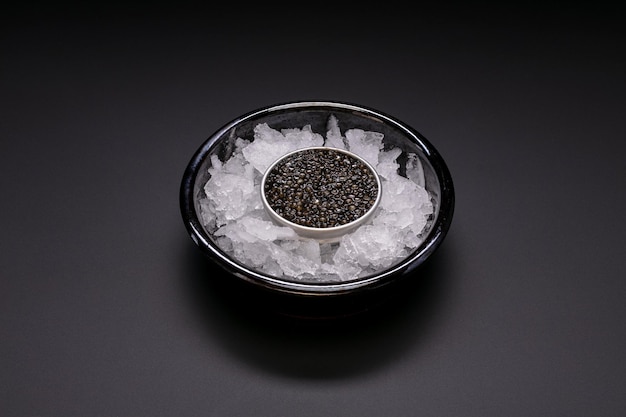 Caviar en una caja metálica sobre hielo sobre fondo negro