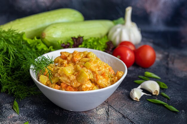 Caviar de calabacín, zanahorias y cebollas Comida de primavera Vegetarianismo Junto con verduras de primavera En un espacio de copia de fondo oscuro