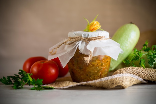 Caviar de abóbora cozido com tomates em um frasco de vidro para preservação