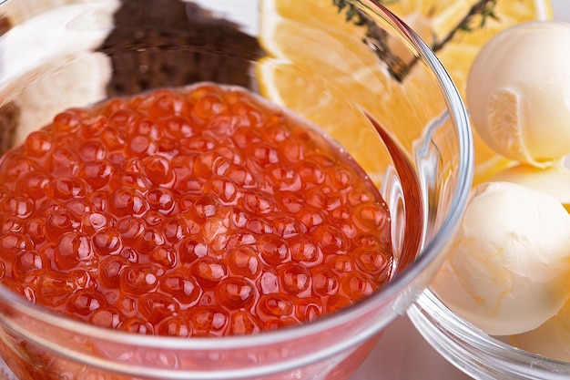 Foto caviar de salmão com pão e manteiga em uma tigela fechar