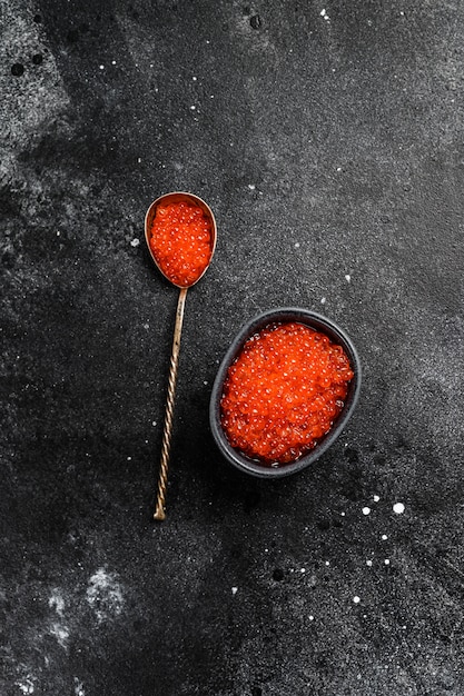 Foto caviar de salmão vermelho em uma colher requintada.