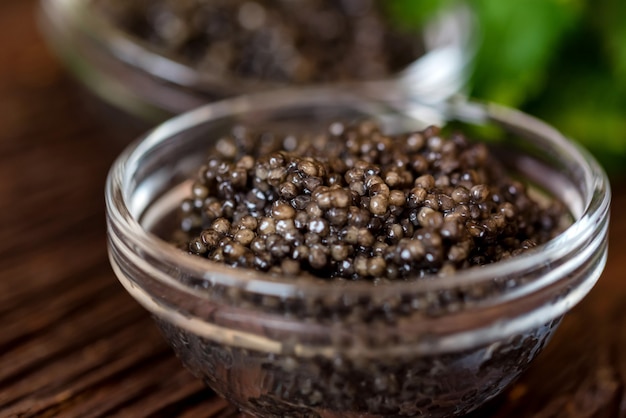 Caviar de esturión negro sobre mesa de madera