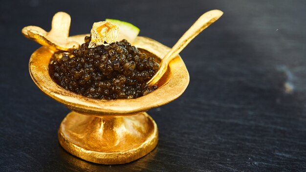 Caviar negro en cuenco dorado. Kelvin superficial.