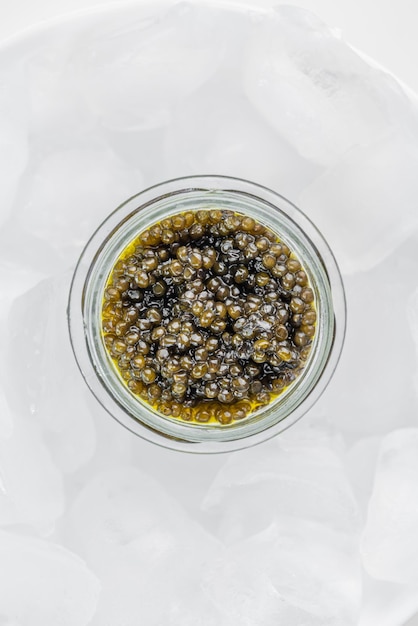 Caviar premium negro en tarro de cristal y cubito de hielo