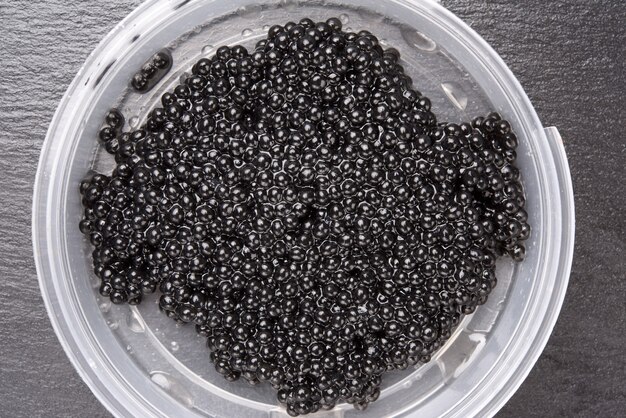 Caviar preto de paddlefish em prato de plástico, comida gourmet e deliciosa, close