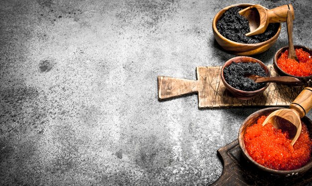 Caviar rojo y negro en cuencos de madera.