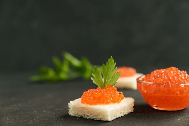 Caviar rojo en pan de trigo, mariscos. Alimentación saludable y dieta. Copiar espacio para texto