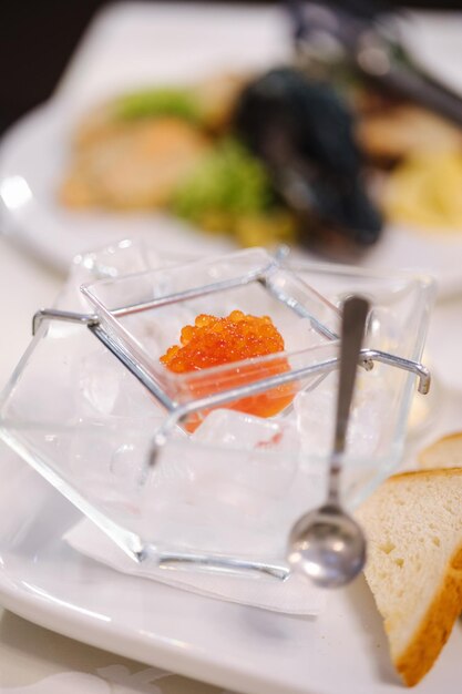 Caviar rojo en un recipiente especial con hielo.