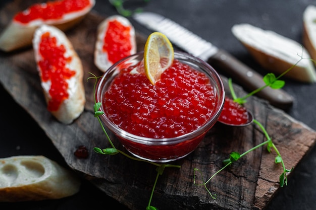 Foto caviar rojo sobre un fondo oscuro sándwiches con caviar