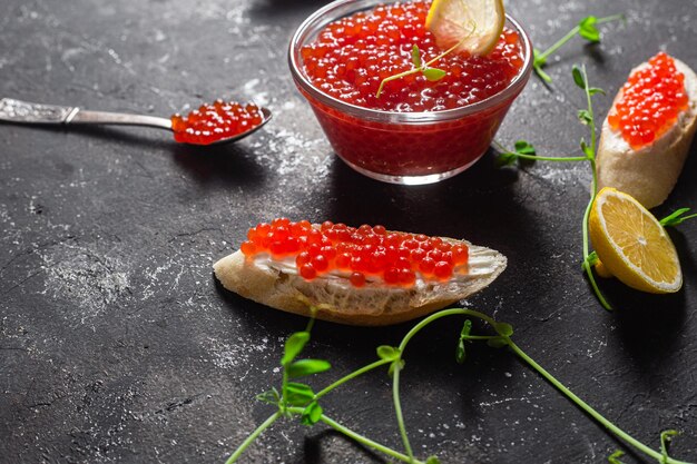 Caviar rojo sobre un fondo oscuro Sándwiches con caviar